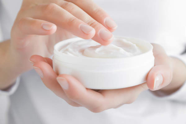 Hands using moisturizer.