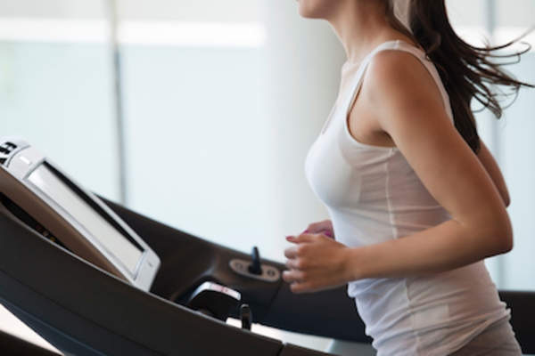 年轻女子在跑步机上跑步。