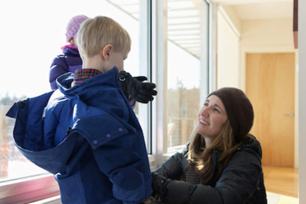 母亲为寒冷的天气给孩子穿暖。