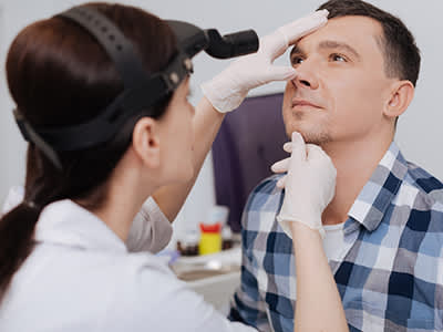 医生检查男人的鼻孔。