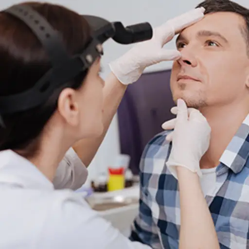 医生正在检查一个男人的鼻孔。