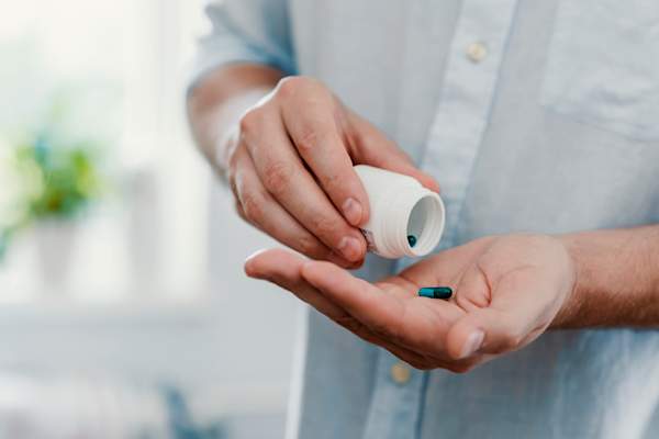 男人的手倒出药丸