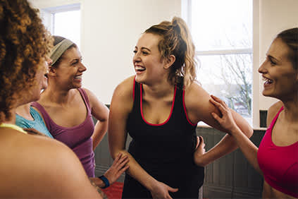 女人笑在锻炼课堂上说话的集团。