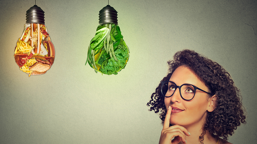 女人的思维健康食品或垃圾食物的灯泡。