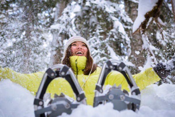 女子雪鞋探险期间在空气中抛雪