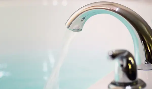 水从水龙头流入浴缸。