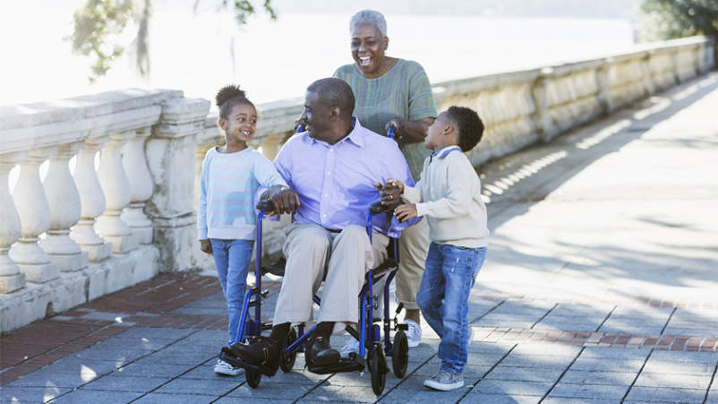 照顾坐轮椅的丈夫和孙子的妇女。