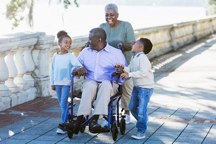 坐在轮椅上照顾丈夫和孙子的妇女。