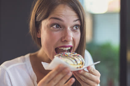 女人要吃掉一个甜甜圈。
