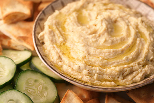 一碗新鲜的鹰嘴豆泥、皮塔薯条和黄瓜。