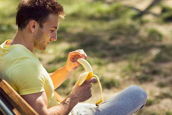 人坐外面在剥香蕉的阳光下。