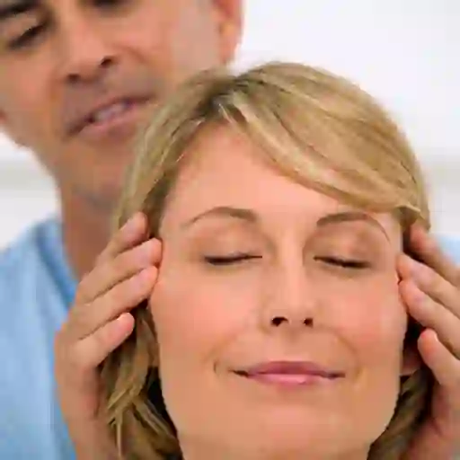 Husband massaging smiling wife's temples.