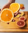 Woman holding an orange above a cutting board
