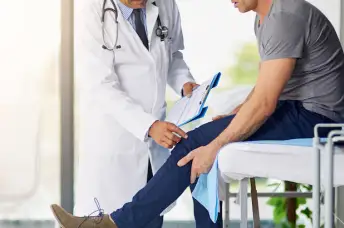 医生检查一个人的腿痛。