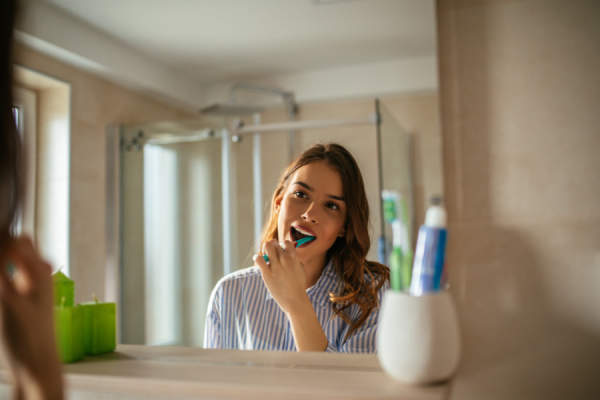 年轻女子刷牙照镜子