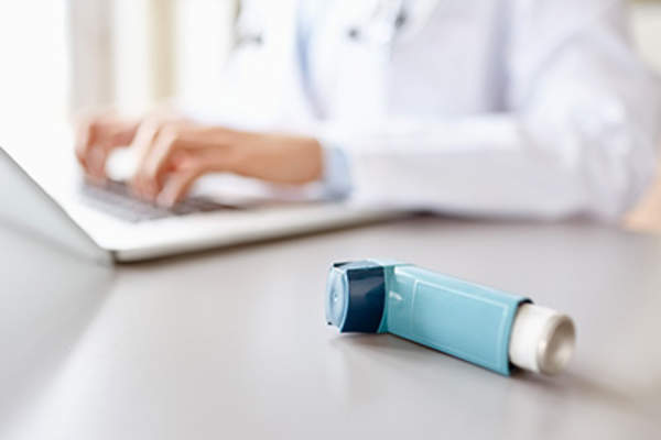 在笔记本电脑上哮喘医生打字。