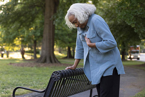 从呼吸急促在公园里的女人的痛苦。