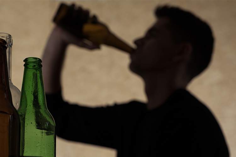 一个十几岁的男孩在喝啤酒。