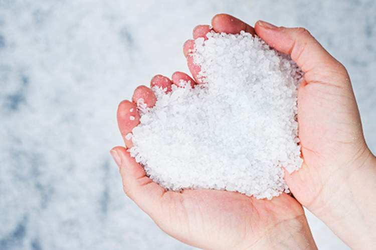 人拿着心脏形堆盐在自己手中。
