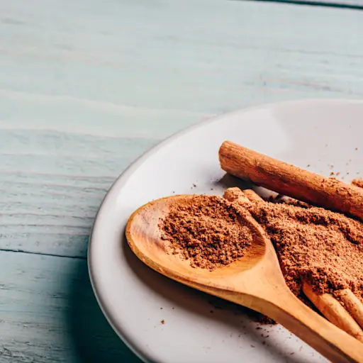 Cinnamon in powder and stick form on white plate