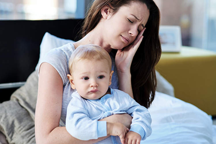 压力很大的母亲抱着孩子。