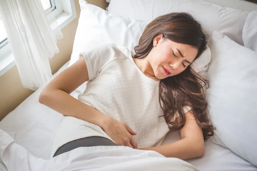 躺下与严重的胃痉挛和痛苦的少妇。