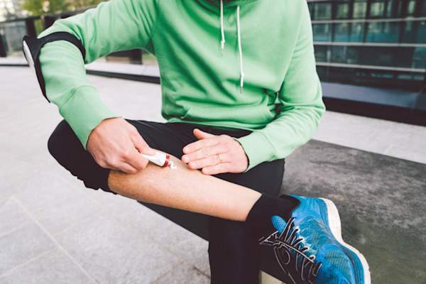 在腿上涂药膏的人