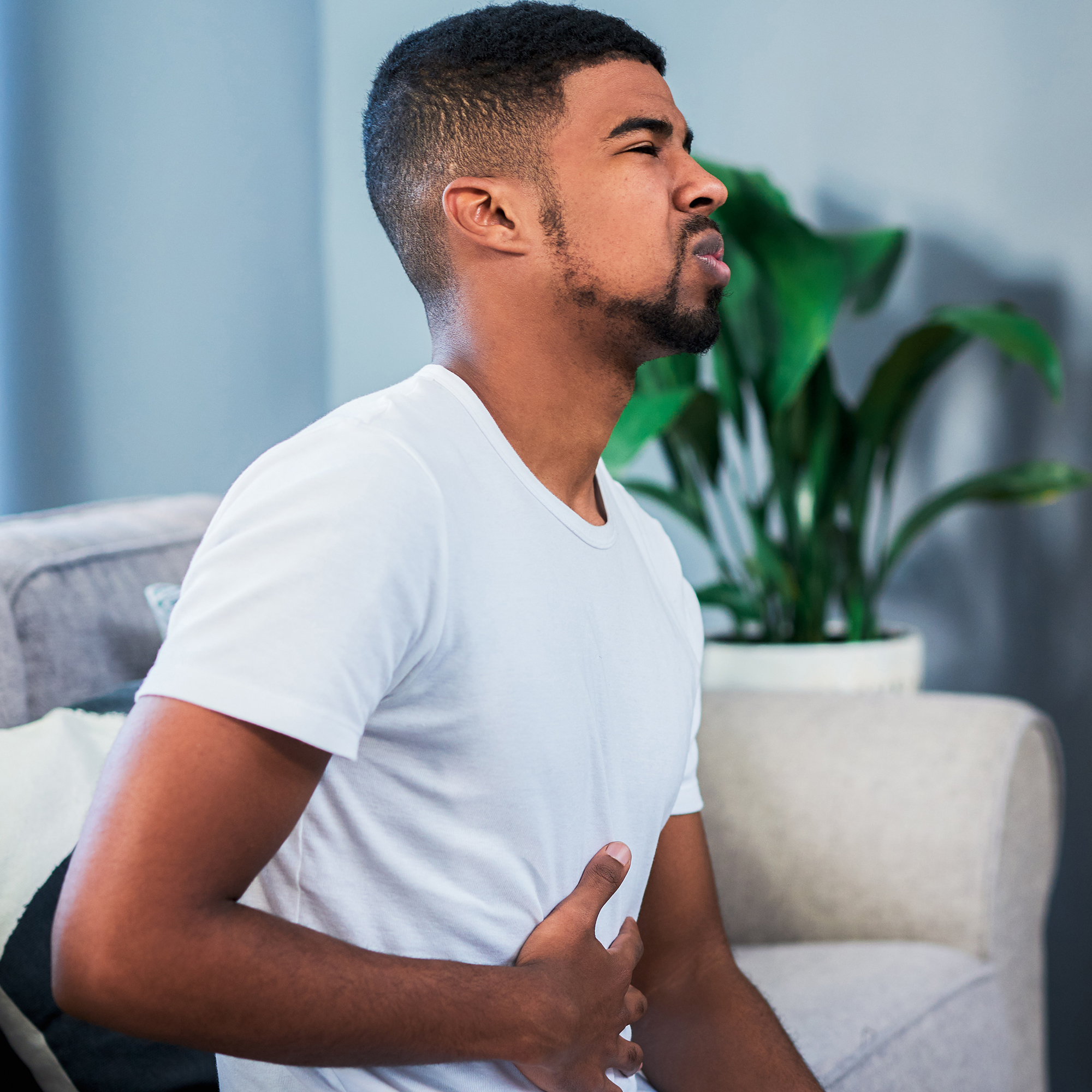 男人疼得捂着肚子。