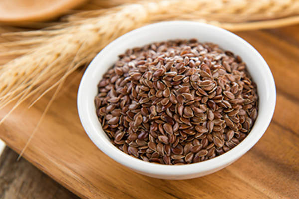 亚麻籽在白色的碗上木桌。