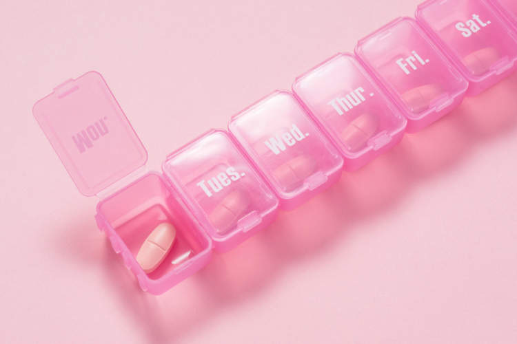 在粉红色的背景粉红色的药丸盒