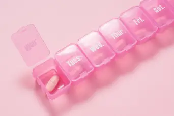 粉色背景上的粉色药丸盒