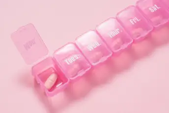 粉红色背景上的粉红色药丸盒