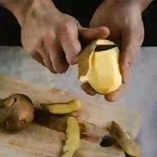 man's hands peeling potatoes