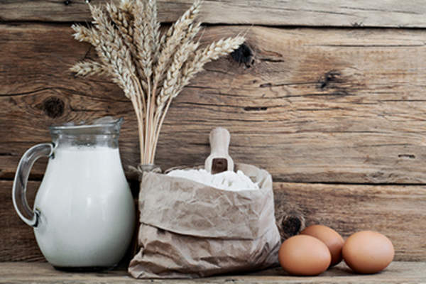 一袋面粉,上面有小麦、牛奶和鸡蛋的小穗。