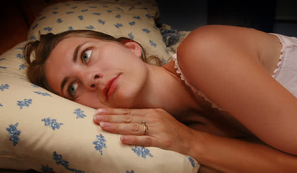 患有失眠症的妇女醒着躺在床上。