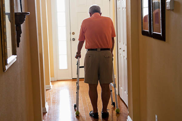 学长用助步车在家里四处走动。