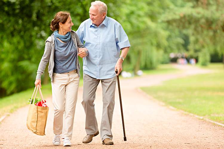Senior walking with his caregiver.