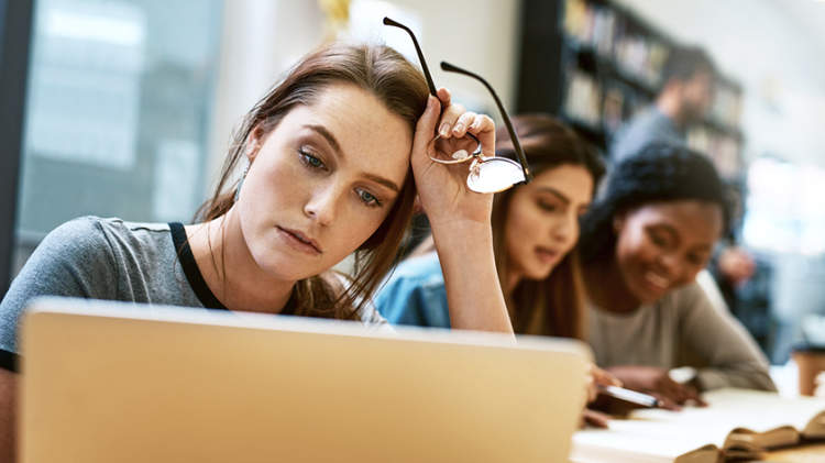 压力大的年轻女人在笔记本电脑上。