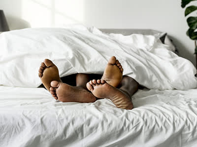夫妇的脚在床上。