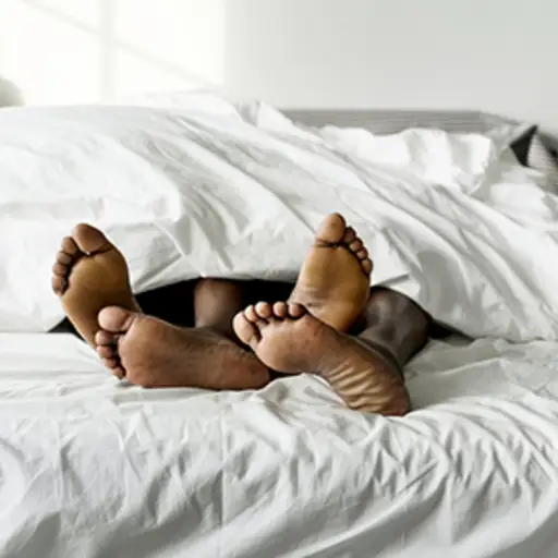 情侣的脚在床上。