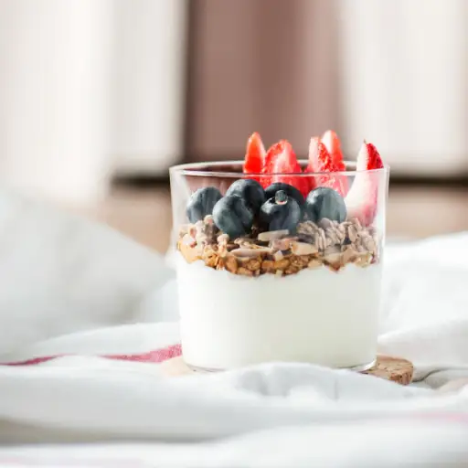 酸奶用水果和格兰诺拉麦片在床上