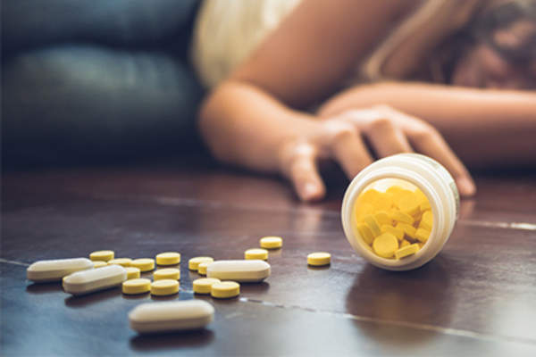 女人,药物过量躺在地板上。