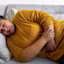 Woman suffering from stomach cramps on the sofa at home