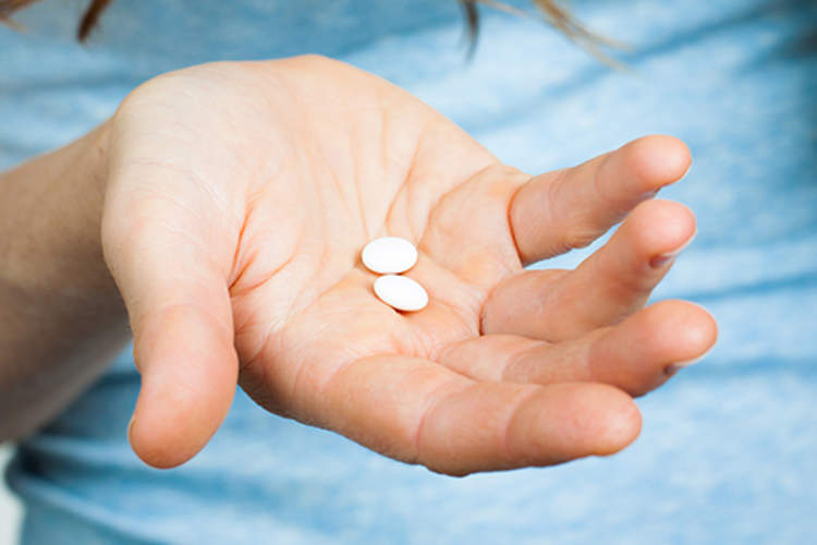 手握药丸的特写。