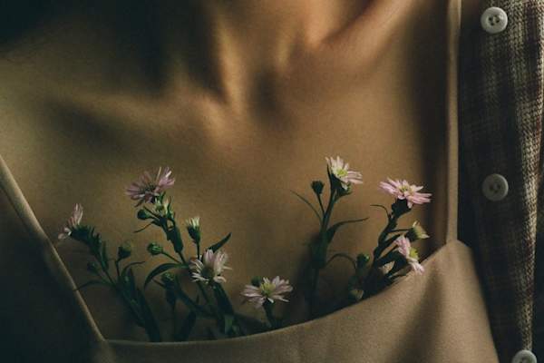 close up of woman's chest with flowers in shirt