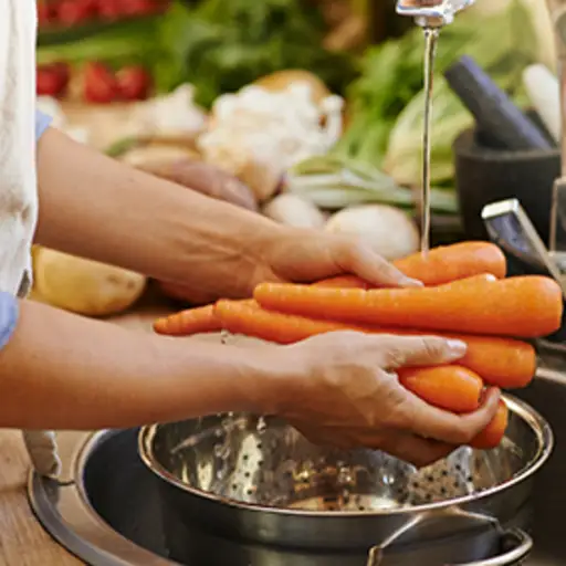 Woman washing carrots.