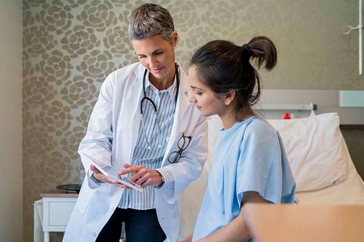 医生给一位年轻的病人看药片。