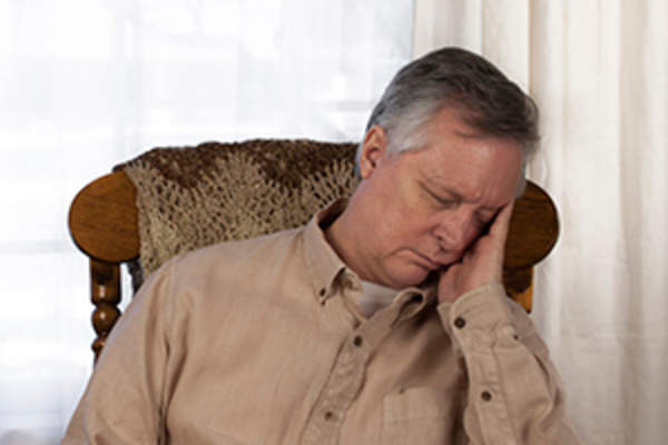 当天图像中的老人睡在椅子上。