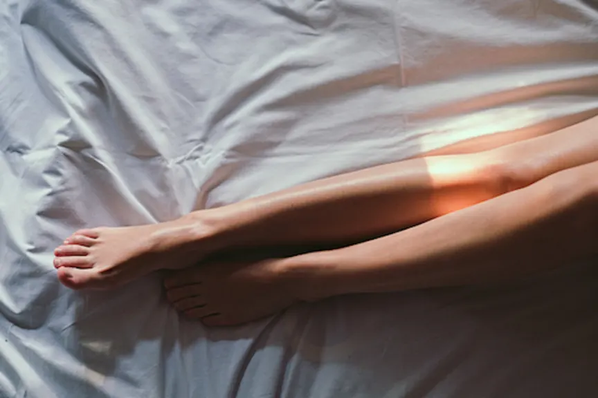 女人的腿在床上。
