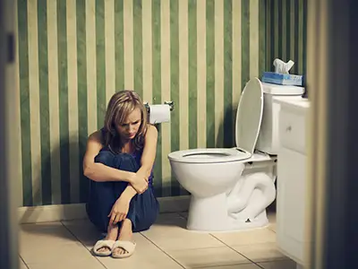 哀伤的少妇坐地板在卫生间里。